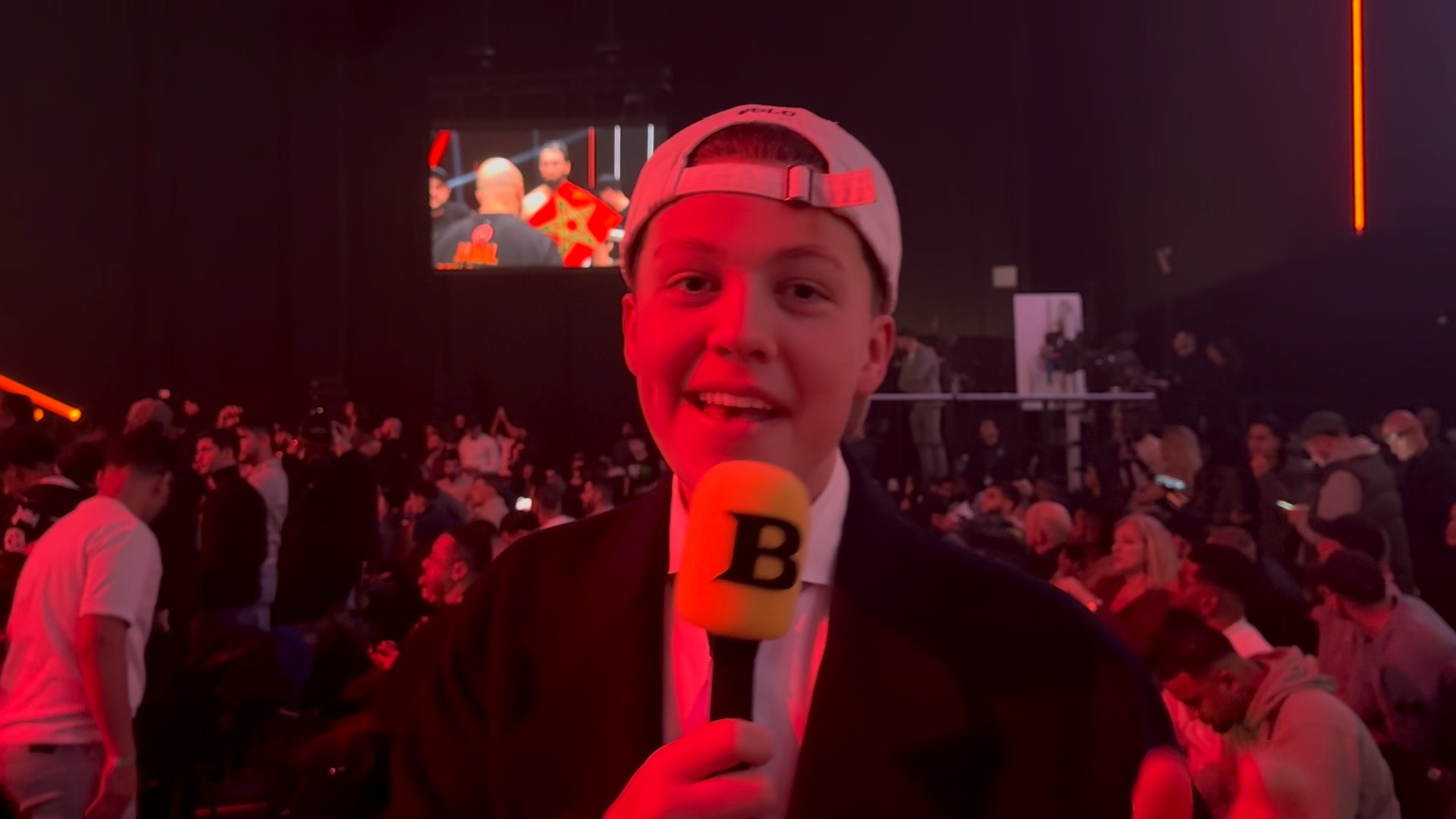 Bender met de gele microfoon in de zaal bij een bokswedstrijd